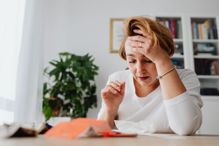 Overprikkeld: vrouw houdt haar hand tegen haar voorhoofd