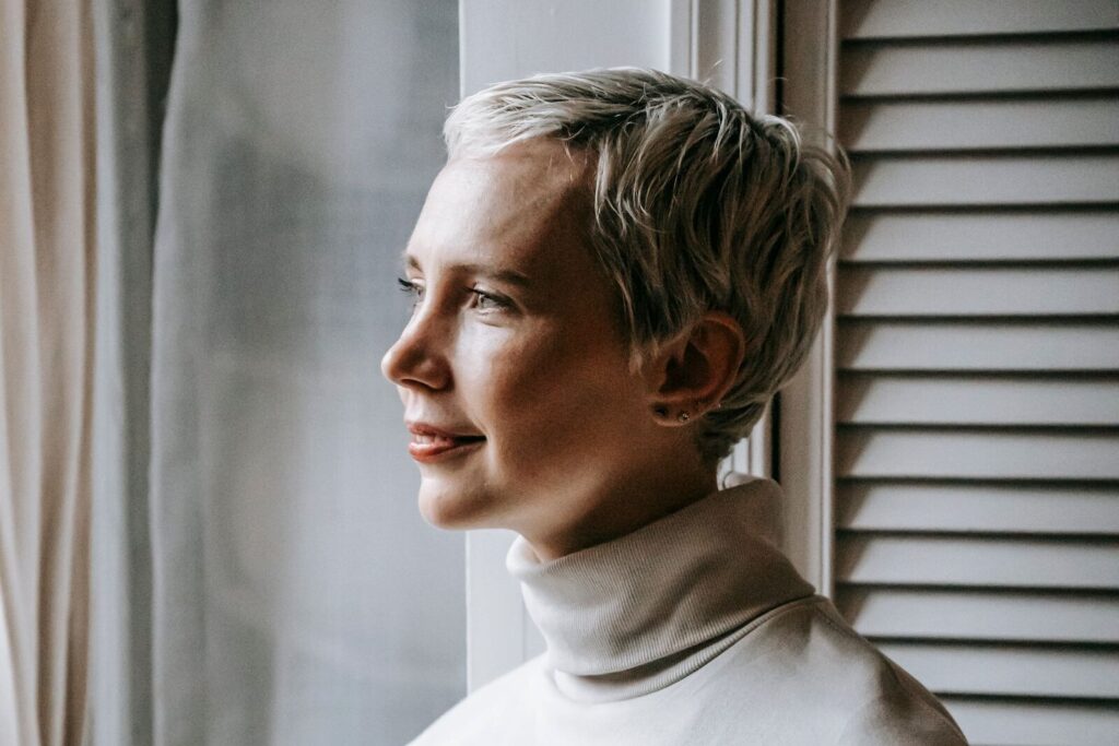 Vastzitten in je gedachten: vrouw kijkt nadenkend uit het raam