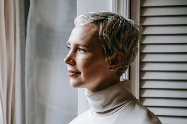 Vastzitten in je gedachten: vrouw kijkt nadenkend uit het raam