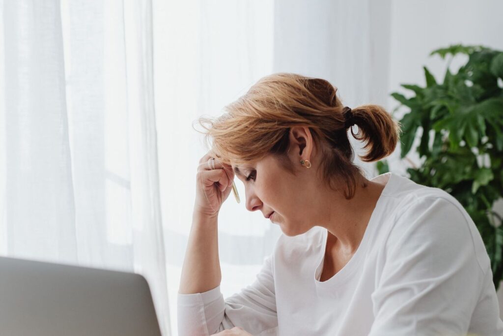 Grip kwijt: vrouw zit bezorgd achter haar laptop