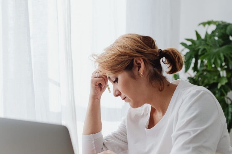 Grip kwijt: vrouw zit bezorgd achter haar laptop