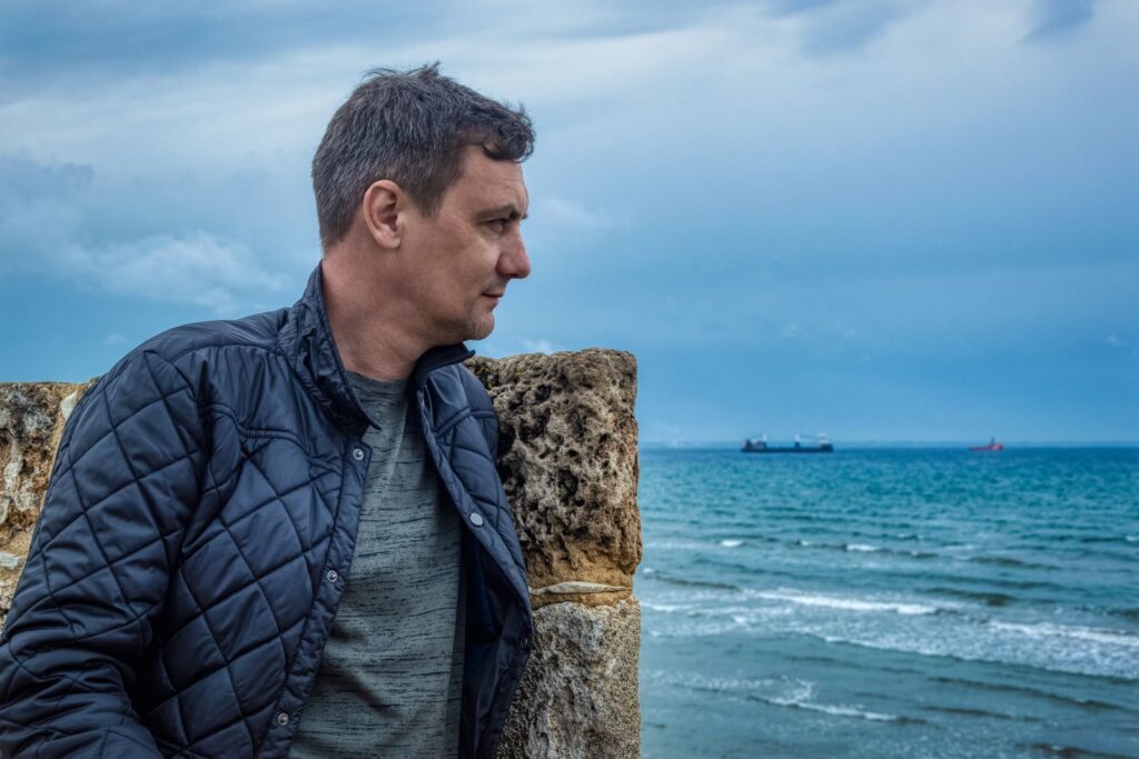Weinig zelfvertrouwen: man kijkt nadenkend uit over de zee